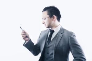 スマホを不安そうに見るサラリーマン
