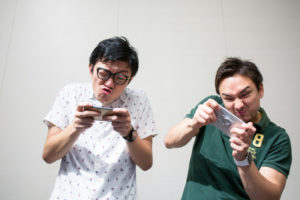 スマホで遊ぶ二人の大人